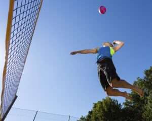 volley player mid-air attempting to hit volleyball - kansas-city-sports-medicine